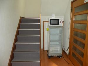 德岛港区民宿商务酒店的楼梯旁冰箱顶部的微波炉