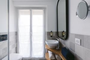 巴黎小型舒适酒店的一间带水槽和镜子的浴室