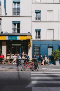 巴黎小型舒适酒店的一群坐在大楼外桌子上的人