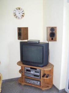 博尔滕哈根Zur-alten-Schmiede-II-Wohnung-unten-II的台上带扬声器和时钟的电视