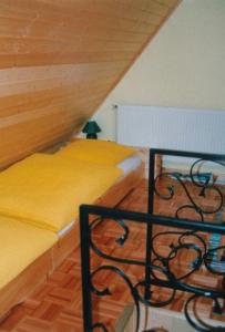 博尔滕哈根Zur-alten-Schmiede-I-Links的阁楼卧室配有两张带黄床单的床