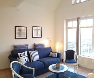 奥斯特巴德里克Ferienwohnung-Meeresblick-Rerik的客厅配有蓝色的沙发和两把椅子