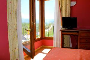 Badarán孔德德巴达兰酒店的客房设有一张床和带电视的窗户。
