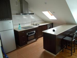里瓦德奥Apartamento Ría de Ribadeo的厨房配有水槽和炉灶 顶部烤箱