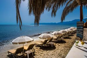 赫索尼索斯Cosmopolis Crete Suites的海滩上的一排椅子和遮阳伞