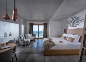 赫索尼索斯Cosmopolis Crete Suites的一间卧室配有一张床,客厅配有桌子