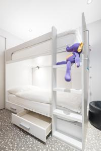 尚佩里Hôtel Le White - Le 42 Restaurant的一间卧室配有带紫色玩具的双层床