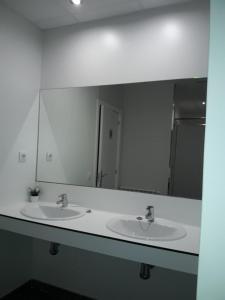 帕德隆Albergue Camiño Do Sar的一间带两个盥洗盆和大镜子的浴室