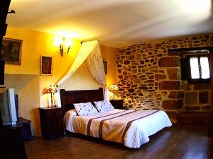 El Ribero帕拉西奥德洛斯阿尔瓦拉多旅馆的一间卧室设有一张床和石墙