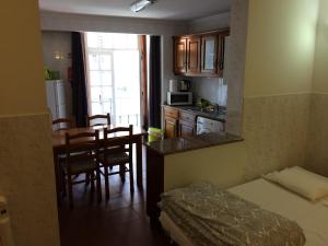 波尔图Downtown PORTO SE的小房间设有一张床和一个带桌子的厨房