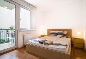 布达佩斯可爱考文公寓的一间卧室设有一张床和一个大窗户
