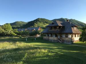 上维谢乌Magnolia Resort Chalets的山地草坪上的房屋