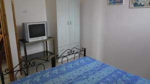 科尔萨诺Villetta Gelsomino的一间卧室配有一张带蓝色床单的床和一台电视。