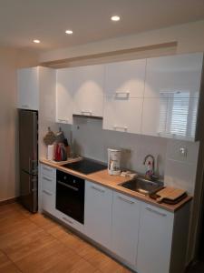 拉布Apartment Maria的厨房配有白色橱柜和水槽
