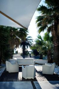 葛伦坦马勒罗马酒店的庭院设有白色椅子和棕榈树