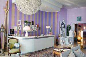葛伦坦马勒罗马酒店的更衣室设有紫色墙壁、沙发和桌子