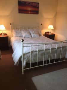 韦斯特波特Ceol Na Mara的卧室配有带两盏灯的白色床