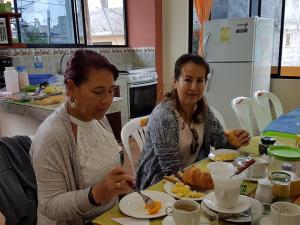 阿约拉港Hostal Casa Cascada的两个坐在餐桌上吃食物的女人