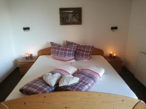 贝旺豪斯兰姆酒店的一间卧室配有一张带枕头和两张蜡烛的床。