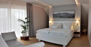 加姆利茨维依丽芙时布罗利酒店的卧室配有白色的床和沙发