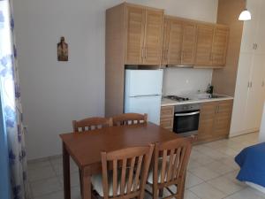 LivadakiaMedusa Accommodation的厨房配有木桌和白色冰箱。