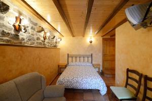 托尔拉Habitación El Mirador Casa Cajal的一间带一张床铺的卧室,位于一个带沙发的房间