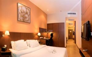 Kuala Belait瑞士公寓酒店的一间酒店房间,里面摆放着一张床上的动物