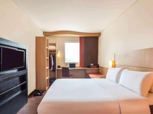 泗水泗水市中心宜必思酒店的酒店客房设有一张大床和一台电视。