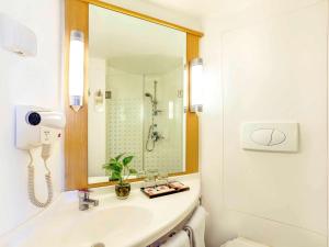 泗水泗水市中心宜必思酒店的白色的浴室设有水槽和镜子