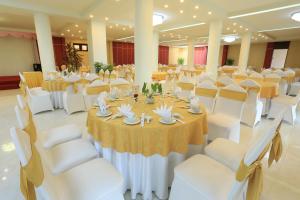 大叻凯华达拉特酒店的宴会厅配有白色的桌子和白色的椅子