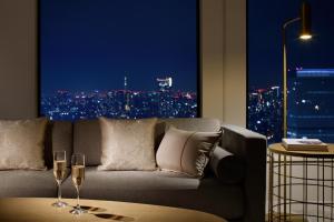 东京京王广场东京尊贵大酒店的客厅配有沙发和两杯葡萄酒