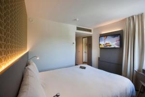 科特赖克宜必思风格科特赖克博览会酒店的酒店客房设有一张床和墙上的电视