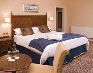布莱克浦布莱克浦帝国酒店的酒店客房设有一张大床和一张桌子。