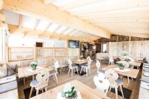 罗登戈Ahner Berghof的餐厅拥有木墙和桌椅
