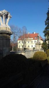 瓦乌布日赫城堡酒店的白色的建筑,有红色的屋顶和雕像