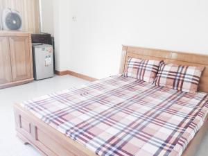 芽庄Chang Homestay的卧室内的一张带棉质棉被和枕头的床