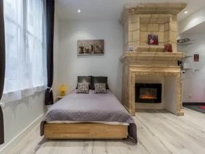 波尔多Appart Cozy / Quartier St Pierre的一间卧室配有一张床和一个壁炉
