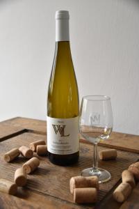 梅灵Gästehaus Weber-Loskill的一瓶葡萄酒和一张木桌上的玻璃杯