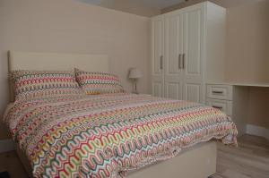 库特希尔Blessings Studio Apartments的一间卧室配有一张大床和色彩缤纷的被子