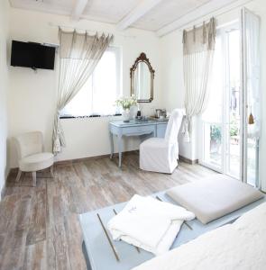 莱万托瓦伦蒂娜别墅酒店的白色的客厅配有桌子和书桌
