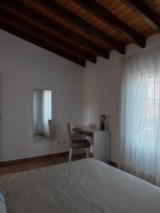 BicosVales do Alentejo的卧室配有1张床、1张桌子和1把椅子