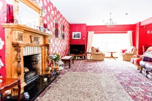 GarrisonMelvin Country House的客厅设有红色的墙壁和壁炉