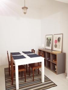 蒙蒂戈杜Casa da Madrinha I的一间配备有白色桌椅的用餐室