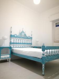 蒙蒂戈杜Casa da Madrinha I的白色墙壁的房间里一张蓝色的床