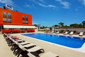 奎特里拉卓地雅阁酒店的一座带躺椅的游泳池位于大楼旁