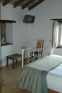 马尔旺Quinta Do Vaqueirinho - Agro-Turismo的一间卧室配有一张床、一张长凳和一台电视。
