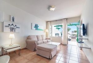 卡门港Apartamentos LIVVO Las Gaviotas的客厅配有沙发和桌子