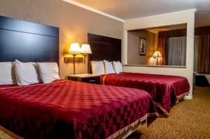 萨克拉门托萨克拉门托行政套房酒店的酒店客房,配有两张带红色床单的床