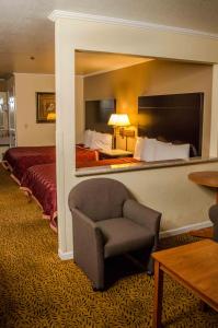 萨克拉门托萨克拉门托行政套房酒店的酒店客房带椅子和床