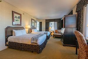 路易斯威尔布朗酒店的大型酒店客房,配有两张床和椅子